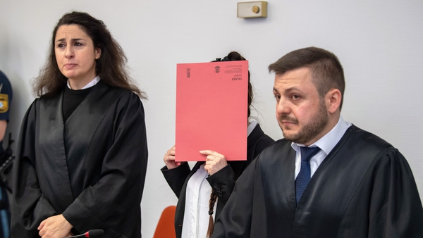 Defendant Jennifer Wenisch hides her face behind a folder as she arrives at court