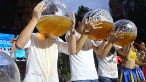Tourists drink beer out of fishbowls during a beer-drinking competition in Hangzhou, China