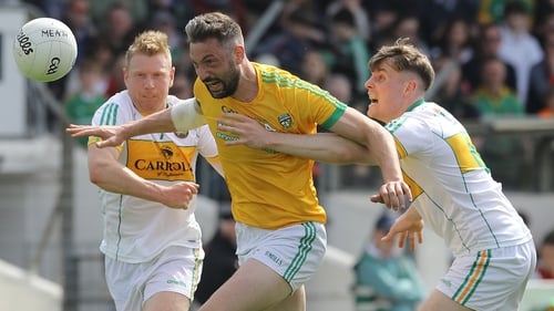 Meath forward Mickey Newman is tackled by Niall Darby and Johnny Moloney