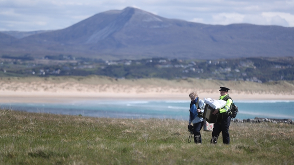 Presiding Officer Carmel McBride and Garda Adrian McGettigan carry a ballot box from the polling station on Inishbofin Island