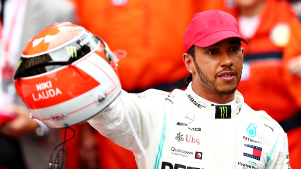 Lewis Hamilton holds up his Niki Lauda-inspired helmet following the victory in Monaco