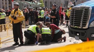 Police officers and paramedics attend to an injured person after the shooting