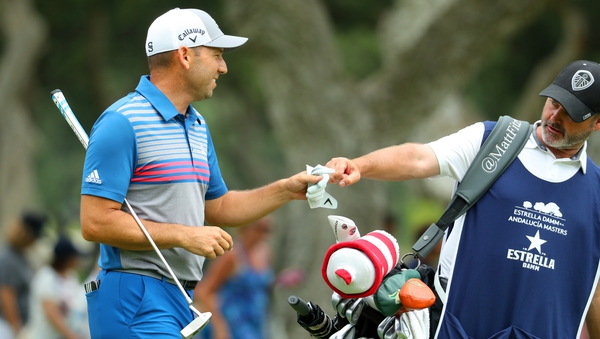 Sergio Garcia fist bumps Matt Fitzpatrick's caddie Billy Foster after his second shot on the 9th hole