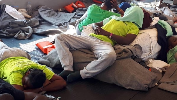 Migrants resting on a boat in the Mediterranean Sea