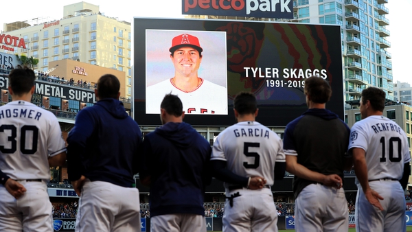 Players for the San Diego Padres and San Francisco Giants stand during a moment of silence for pitcher Tyler Skaggs of the Los Angeles Angels