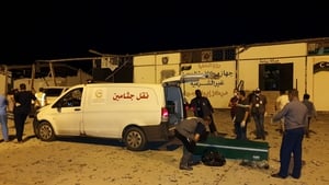 Emergency workers recover bodies after an airstrike at the Tajoura Detention Center, east of Tripoli