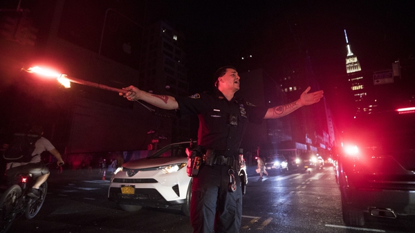 A police controls traffic after a massive power failure hit parts of Manhattan, in New York