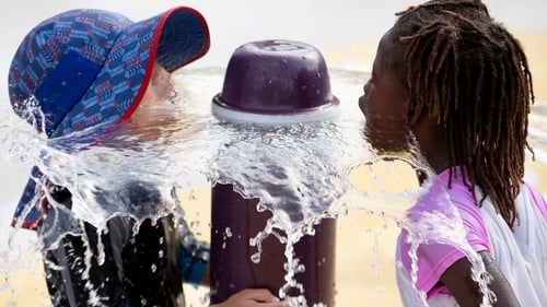 Children cool off at a water fountain in Washington DC