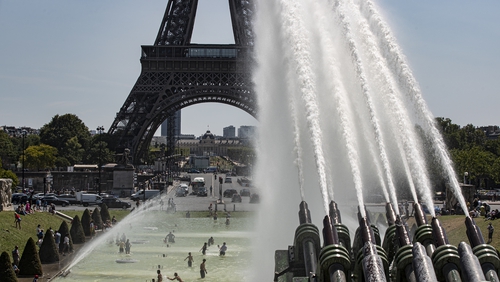 People cool down at the fountains of Trocadero, across from the Eiffel Tower