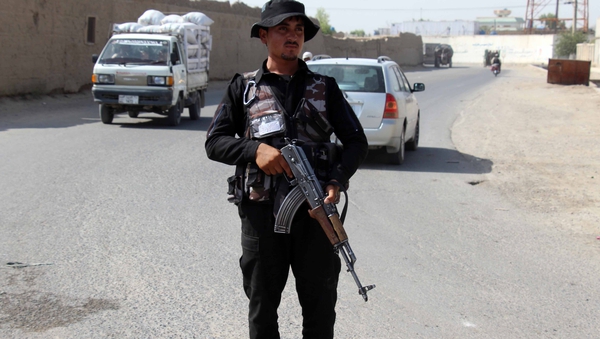 An Afghan security official keeps watch at a checkpoint on a roadside in Kandahar