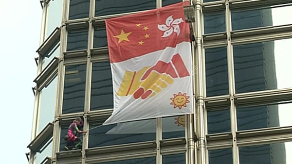During the climb Robert attached a banner featuring the Hong Kong and Chinese flags, as well as two hands shaking