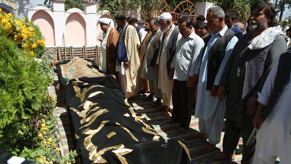 People attend a funeral ceremony after yesterday's suicide attack
