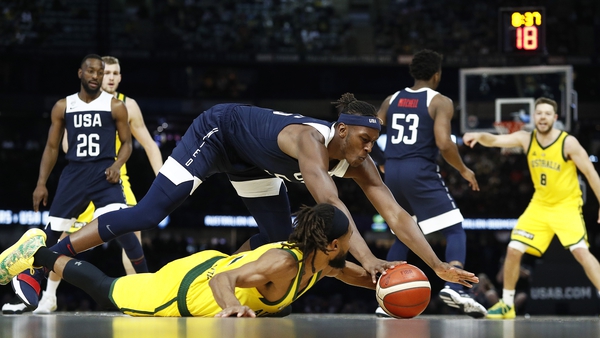 Australia's Patty Mills, on the floor, and Myles Turner of the USA contest the ball.