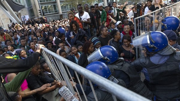 South African police try to stop protesters as they breach the perimeter of the Cape Town International Convention Centre, which is hosting the World Economic Forum on Africa