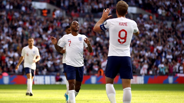 Raheem Sterling celebrates scoring his side's third goal at Wembley with England captain Harry Kane