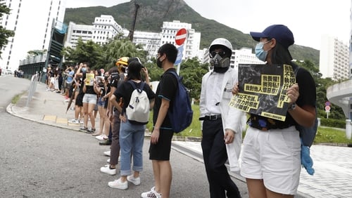 Before school started, rows of students and alumni joined hands chanting 'Hong Kong people, add oil'