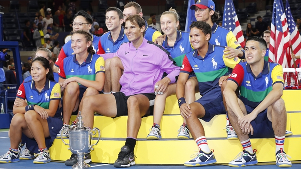 Rafael Nadal poses with the US Open trophy and ball kids after recording his fourth success in New York