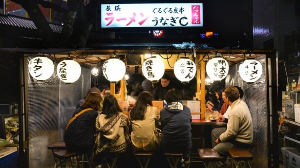 People are having dinner at Yatai, local food stand, along the river near Canal city, Fukuoka, Japan