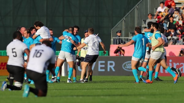 Uruguay players celebrate and Fiji slump to the ground