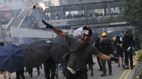 Anti-government protester throws a fire bottle towards police officers