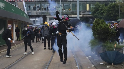 An anti-government protester throws a tear gas canister back at police during a protest in Hong Kong