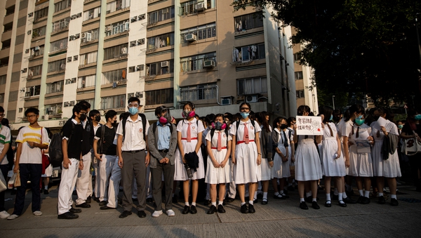 Students stand outside the Tsuen Wan Public Ho Chuen Yiu Memorial College during a demonstration held to show solidarity with an injured student