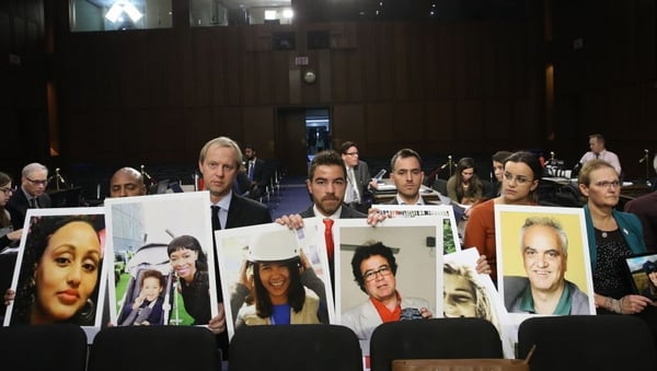 Families of those who died aboard Ethiopian Airlines Flight 302 sit with pictures of their loved ones during the hearing