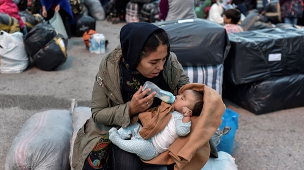 A woman feeds her baby after their arrival from the island of Lesbos to the port of Piraeus near Athens in early October