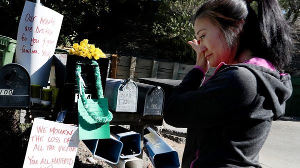 A woman reads sympathy messages for the victims who died at an Airbnb rental house in Orinda, California last week
