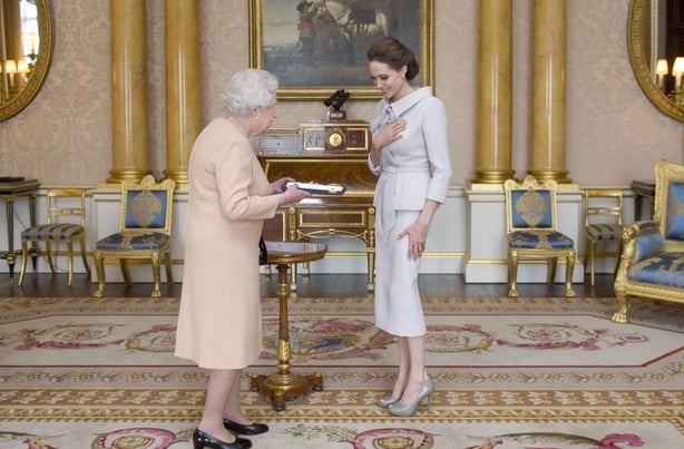 The Qυeen presents Jolie with an order of chivalry (Anthony Devlin/PA)