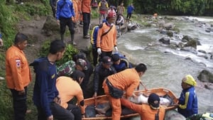 Rescuers retrieve a body from a river at the scene of the crash