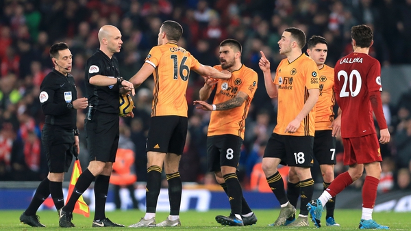 Conor Coady (16) and other Wolves players argue with referee Anthony Taylor