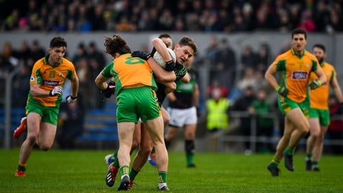 Kevin O'Donovan of Nemo Rangers is tackled by Kieran Molloy of Corofin