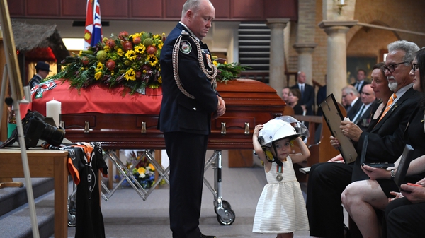 Charlotte O'Dwyer wears her father's helmet during his funeral service