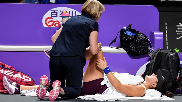 A medical staff checks the knee of Bianca Andreescu of Canada during her women's singles match against Karolina Pliskova of Czech Republic in the WTA Finals tennis tournament, in Shenzhen