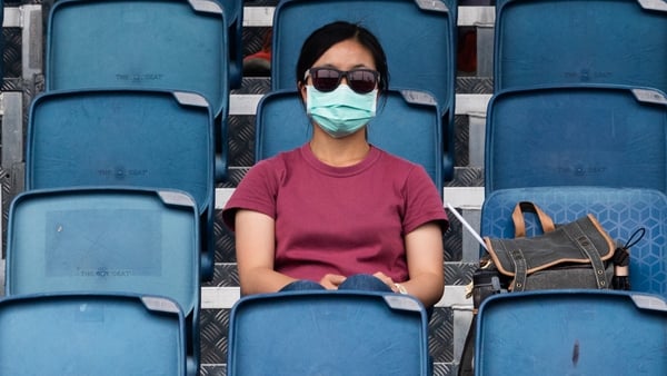 A masked woman watches an Australian Open practice session in Melbourne