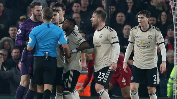 Irate Man United players remonstrate with referee Craig Pawson at Anfield