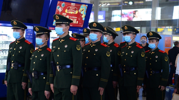 Chinese police officers wearing masks patrol the Hongqiao Railway Station in Shanghai