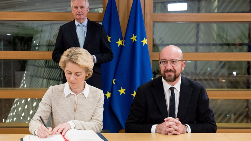 Ursula von der Leyen signs the agreement as Michel Barnier and Charles Michel look on (Pic: @vonderleyen)
