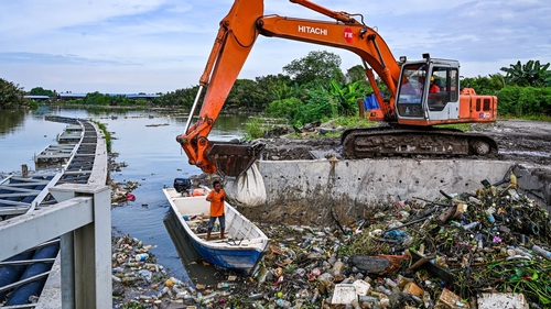 Workers clearing mounds of floating plastic waste on the Klang river on the outskirts of Kuala Lumpur