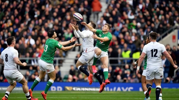 Elliot Daly of England in action against Robbie Henshaw, left, and Jordan Larmour of Ireland