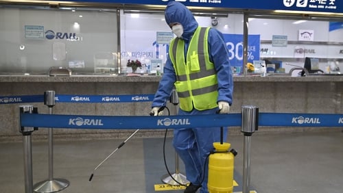 A worker sprays disinfectant at a railway station in Daegu, South Korea
