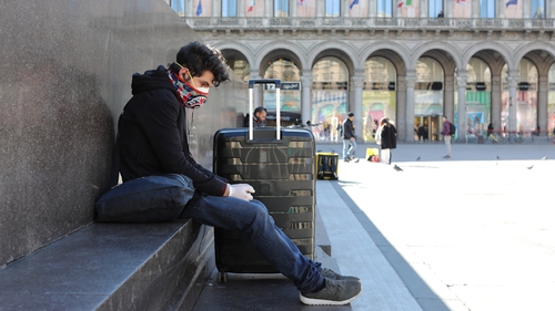 A tourist wears a protective mask and gloves in the Duomo Square, Milan