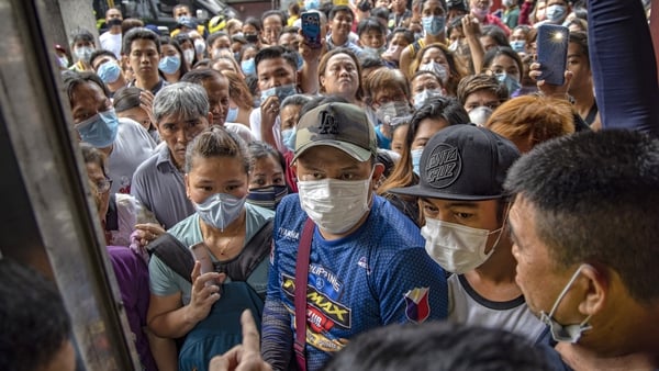 People hoping to buy face masks gather outside a medical supply store in the Philippines