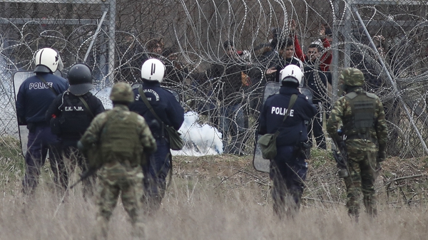 Police try to hold back migrants attempting to cross the border in Kastanies, Greece
