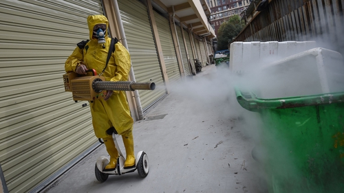 A medical staff member sprays disinfectant at a residential area in Wuhan, China