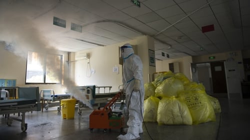 A worker disinfects around the No. 7 Hospital, once designated for only COVID-19 patients, in Wuhan in central China's Hubei province
