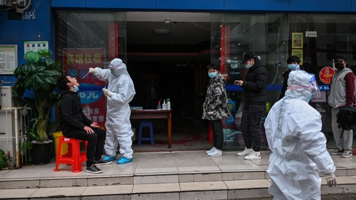 People wait in line to be tested for Covid-19 in Wuhan