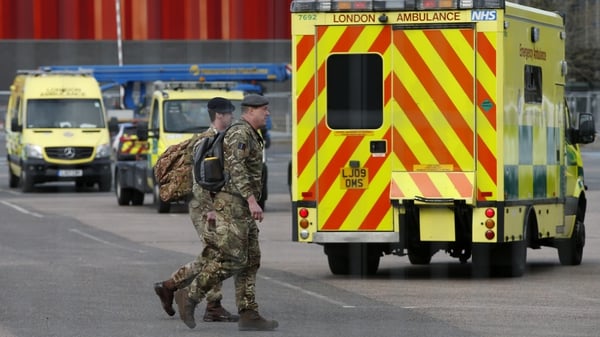 Military personnel stand near London Ambulance Service vehicles at the new NHS Nightingale Hospital at ExCeL London