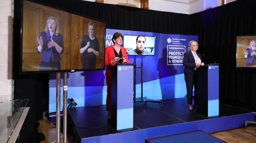Arlene Foster and Michelle O'Neill with two interpreters on screen